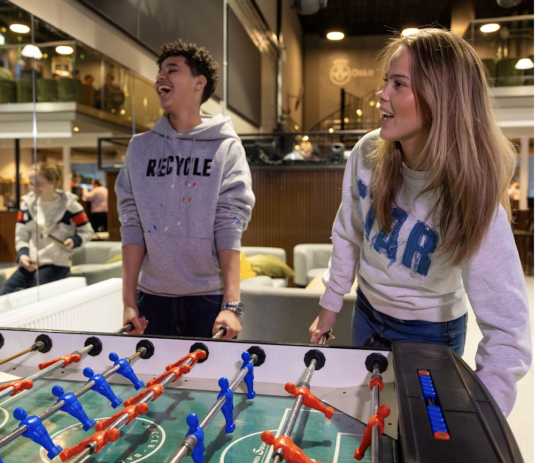 Ungdom på fritidsklubb, gutt og jente, spiller fussball